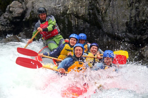 Rafting the Whataroa River, New Zealand - lots of smiles on the faces of a group white water rafting